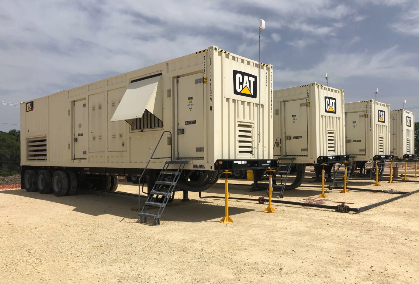 Row of CAT mobile generator units on a construction site.