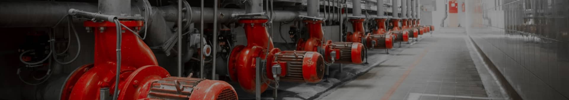 Row of industrial red pumps in a machinery facility.